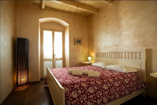 a bedroom with a large bed with a red blanket at ST. JAMES HOME CITTÀ ALTA in Bergamo