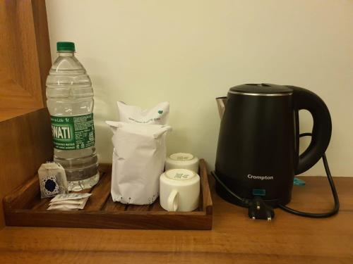 a coffee maker and a bottle of water on a table at HOTEL DEO VOLENTE in Sivasagar