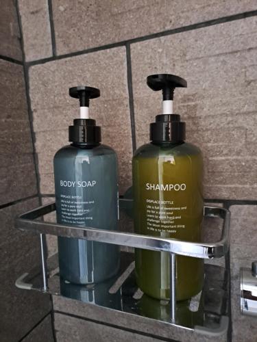 two bottles of soap sitting on a shelf at Be Zen ô Bizet Appartement moderne ultra confort jusqu'à 5 personnes in Le Bizet