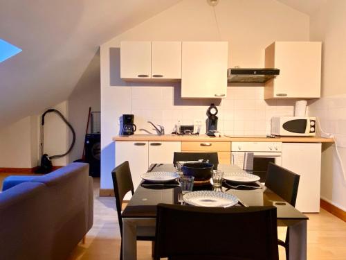 une cuisine avec une table et des chaises dans une cuisine dans l'établissement Le Beau Ciel - 2 lits doubles, bureau, à Auxerre