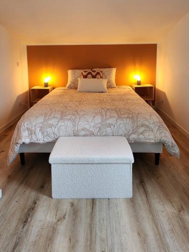 - une chambre avec un grand lit et deux lampes de chaque côté dans l'établissement Le Botanique, à Saint-Médard-de-Guizières