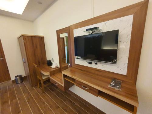 a living room with a large television on a wall at HOTEL DEO VOLENTE in Sivasagar