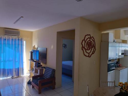 ein Wohnzimmer mit einem Zimmer mit einem Sofa und einem TV in der Unterkunft Praia de Massaguaçu in Caraguatatuba