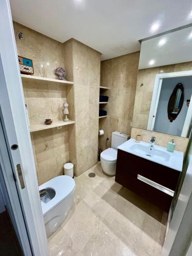 a bathroom with a white toilet and a sink at Sinfonía Azul vistas al mar in Estepona