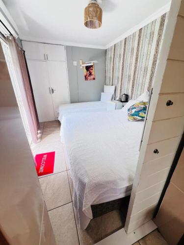 a small bedroom with a large white bed in it at Oteng Lifestyle BnB in Rustenburg
