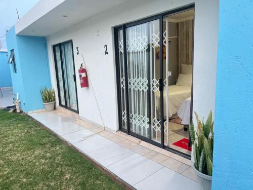 a house with sliding glass doors with a bedroom at Oteng Lifestyle BnB in Rustenburg