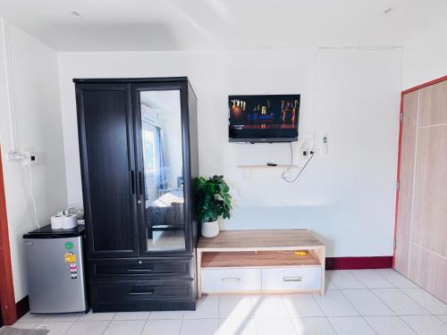 een badkamer met een zwart kastje en een tv bij K.L.Apartment in Chalong 