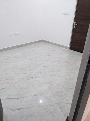 an empty room with a white tile floor at OM Rama Home Stay in Daryābād