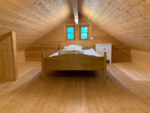 a bedroom with a bed in a wooden cabin at Cabin "Apple" in beautiful Hardanger in Utne