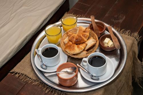 - un plateau/bouilloire avec du café et des croissants sur une table dans l'établissement Las Chuncas Posada Chill Villa de las Rosas, à Villa Las Rosas
