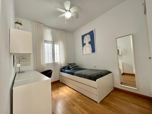 a small bedroom with a bed and a mirror at Sinfonía Azul vistas al mar in Estepona