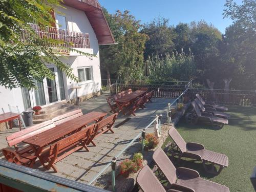 a row of wooden benches next to a building at Attila's Guest House in Budaörs