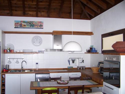 a kitchen with a table and a clock on the wall at Casa El Mirador in Fuencaliente de la Palma