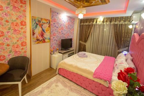 a bedroom with a pink bed and a tv at Marko Paşa Konağı in Kusadası
