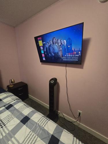 a bedroom with a flat screen tv on the wall at Winnipeg Peace Home in Winnipeg