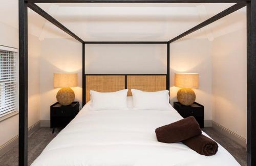 a bedroom with a large white bed with two lamps at Luxury two bed inc hot-tub in Harrogate