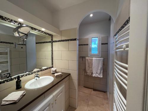 une salle de bain avec un lavabo et un miroir dans l'établissement Appartement de standing Île-Rousse - Grande terrasse vue mer exceptionnelle, à LʼÎle-Rousse