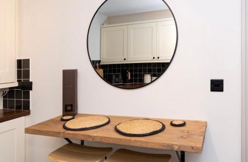 a mirror on a wall above a table in a kitchen at Luxury two bed inc hot-tub in Harrogate