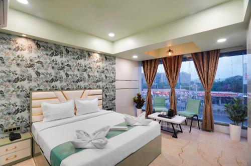 a bedroom with a bed and a desk and a window at Hotel Regal Heaven in Pune