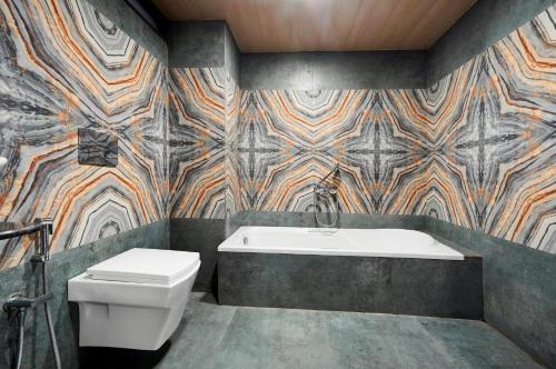 a bathroom with a toilet and a bath tub at Hotel Regal Heaven in Pune