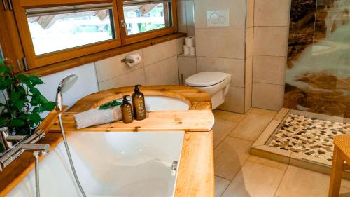 a small bathroom with a tub and a toilet at Buxgarten Ferienhof in Oetz