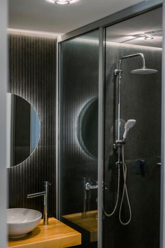 a bathroom with a glass shower with a sink at Legends Hotel Sidari Corfu in Sidari