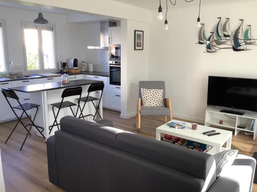 un salon avec un canapé et une cuisine avec une table dans l'établissement Gite Ty ar vor classé 3 étoiles, à Paimpol