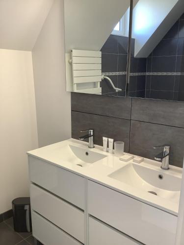 une salle de bain avec un lavabo blanc et un miroir dans l'établissement Gite Ty ar vor classé 3 étoiles, à Paimpol