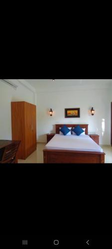 a bedroom with a large bed with blue pillows at New Holiday Reach in Unawatuna