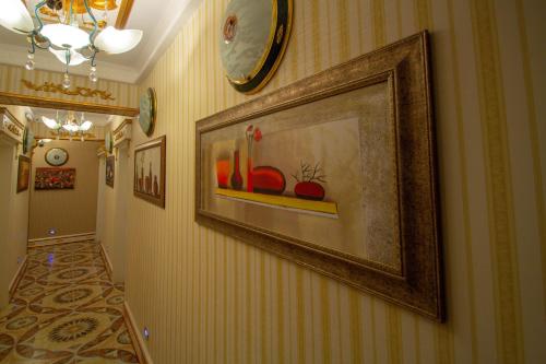 a hallway with a painting on the wall and a clock at Marko Paşa Konağı in Kusadası