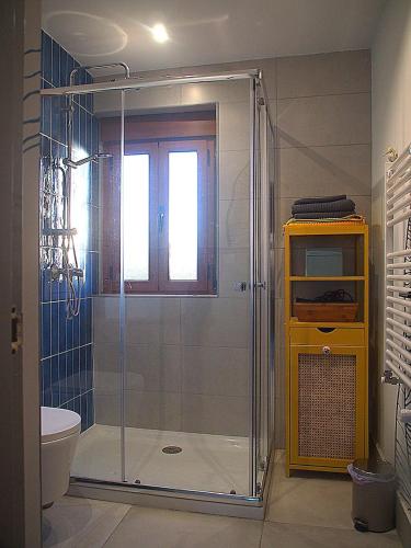 a bathroom with a shower with a glass door at La vida sin reloj a un paseo de la playa in Ancillo