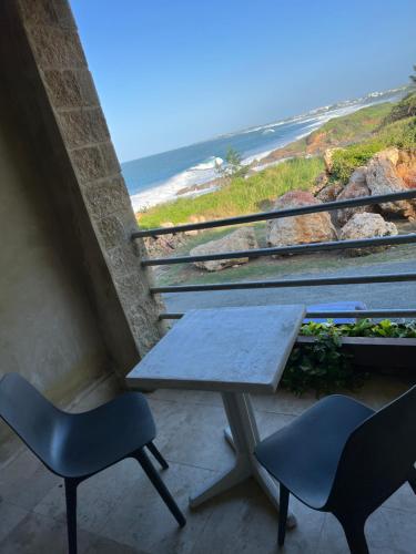 a table and two chairs and a view of the beach at Vacation Rental Arecibo PR in Arecibo