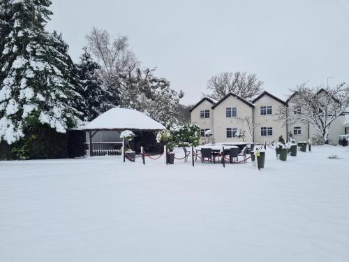 a yard covered in snow with a table and chairs at The Limes Country Lodge Hotel & Admiral Restaurant in Solihull