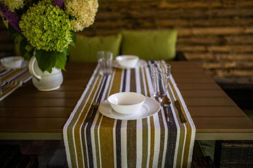 a table with a striped table cloth with two cups and a bowl at Ranczo Stare Objezierze in Moryń