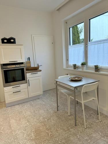a white kitchen with a table and a tv at City Apartment in Köflach