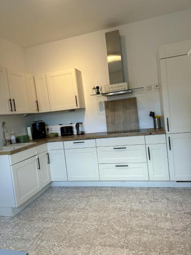 a white kitchen with white cabinets and appliances at City Apartment in Köflach