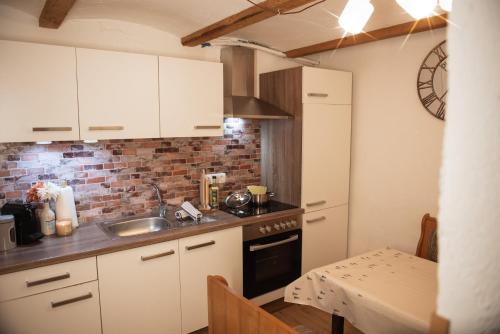 a kitchen with white cabinets and a sink and a table at Appartement Gipfelblick- Tiroler Zugspitze Arena in Biberwier in Biberwier
