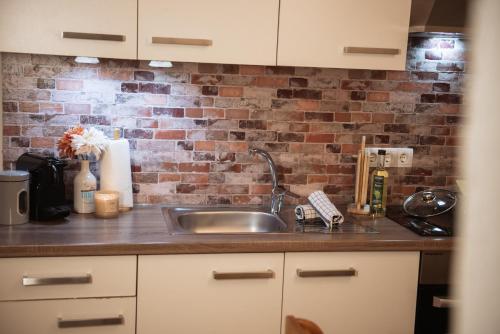 a kitchen with a sink and a brick wall at Appartement Gipfelblick- Tiroler Zugspitze Arena in Biberwier in Biberwier
