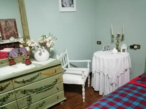 a bedroom with a table and a dresser and a table and chair at B&B La Casa di Rita in Castrezzato