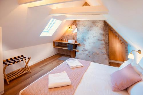 a attic bedroom with a bed and a window at La Maison d'Edouard Spa Chauffé Privé prés du Lac in Lanobre