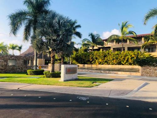 a street with palm trees in front of a building at El Tigre, Isla Palmares with Balcony & Shared Pool in Nuevo Vallarta 