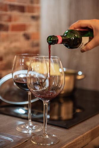 a person pouring wine into a wine glass at Appartement Gipfelblick- Tiroler Zugspitze Arena in Biberwier in Biberwier