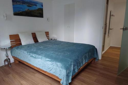 a bedroom with a bed with a blue blanket on it at Villa Kreuzbergl - Doppelzimmer in Klagenfurt