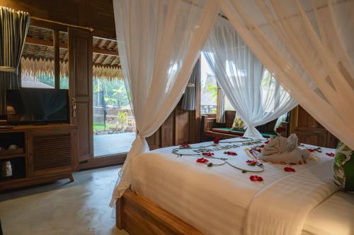 a bedroom with a bed with flowers on it at Lawani Resort in Tegalalang