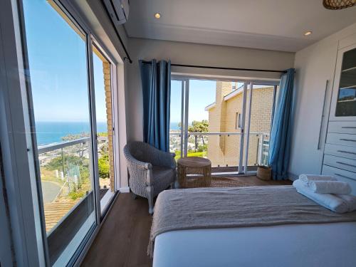 a bedroom with a bed and a view of the ocean at African Sunsets Camps Bay in Cape Town