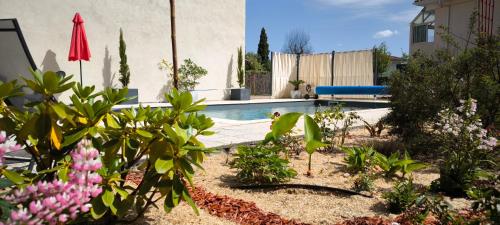 un jardin fleuri et une piscine dans l'établissement Logement cosy, piscine, terrain de pétanque, vélos, entre centre ville et lac, à Parentis-en-Born