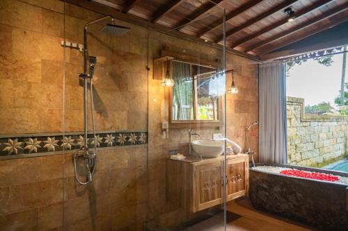 a bathroom with a shower and a sink and a tub at Lawani Resort in Tegalalang