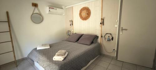 une chambre avec un lit avec deux serviettes dessus dans l'établissement Logement cosy, piscine, terrain de pétanque, vélos, entre centre ville et lac, à Parentis-en-Born