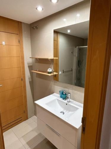 ein Badezimmer mit einem weißen Waschbecken und einem Spiegel in der Unterkunft Luxury Vila Adeje Paradise in Adeje