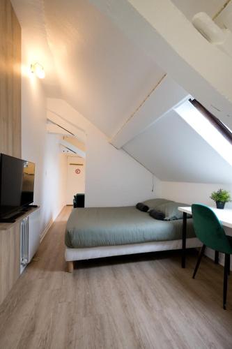une chambre avec un lit, une table et une télévision dans l'établissement Le Nid - Studio in Hypercentre - Cathédrale, à Amiens